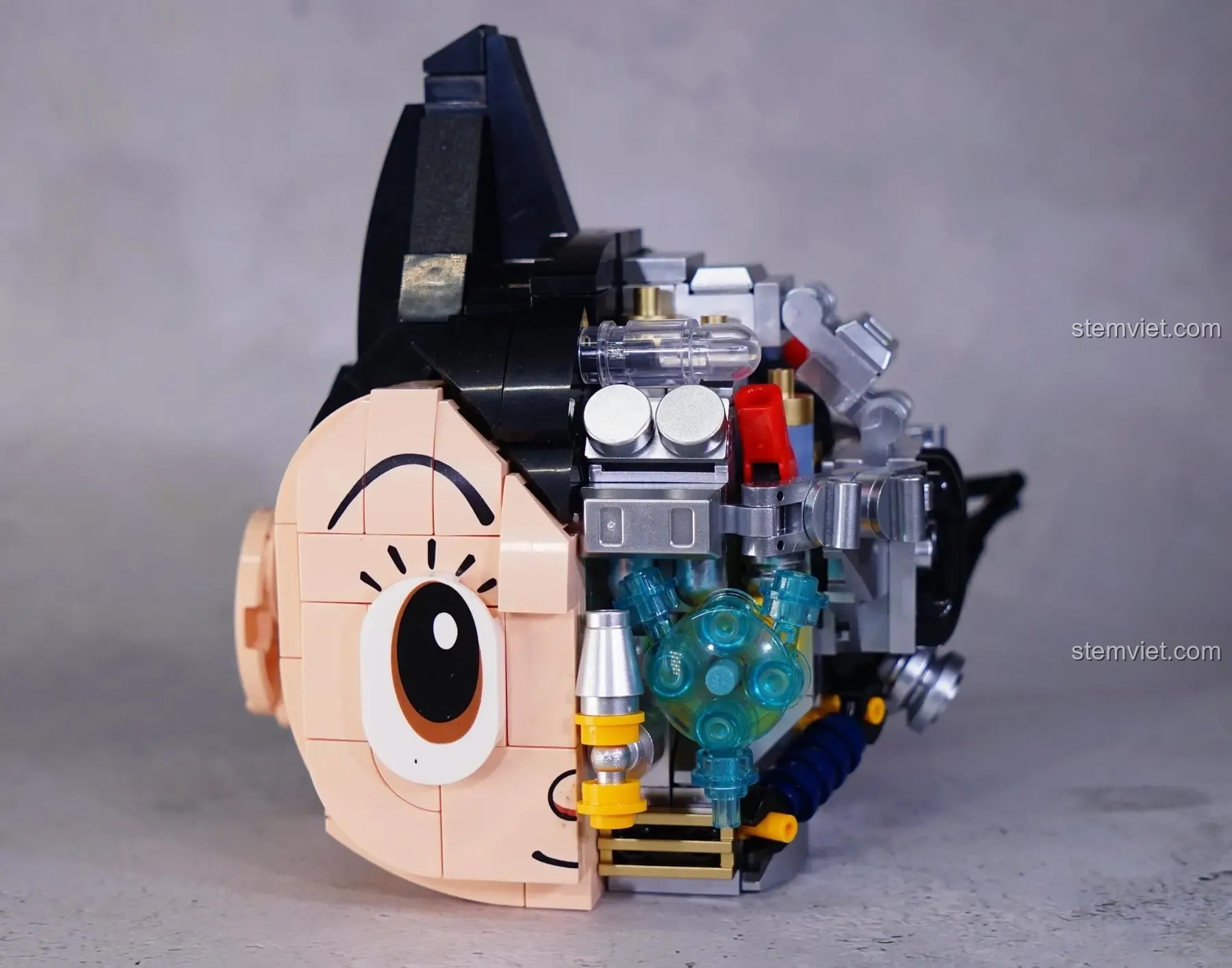 Lắp ráp phần đầu của figure Tượng Astro Boy 86203, phần phức tạp nhất với nhiều chi tiết cơ khí tinh xảo.