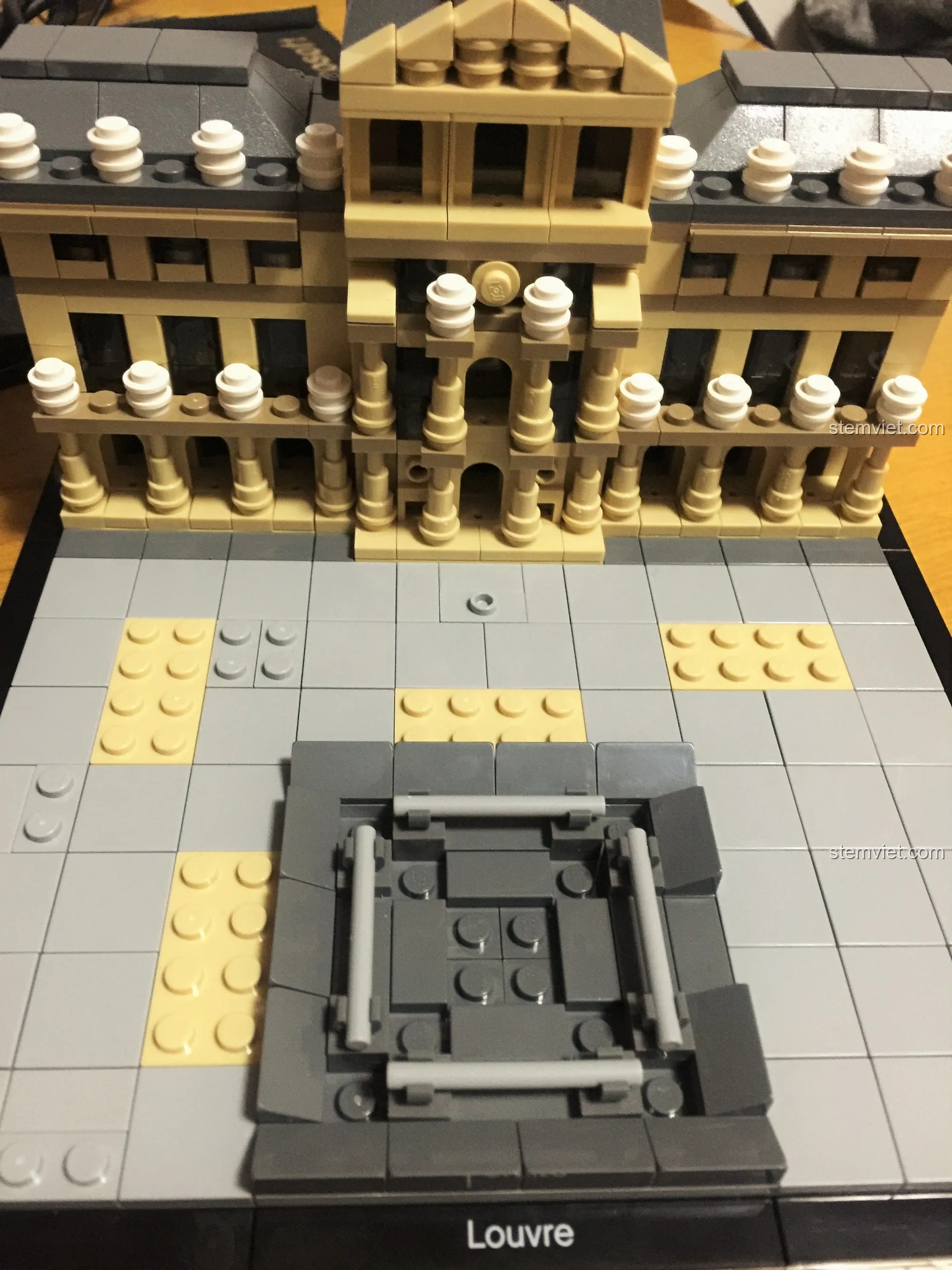 Lắp ráp phần đế cho kim tự tháp kính của bộ LEGO 21024, sử dụng bốn thanh technic để tạo khung.