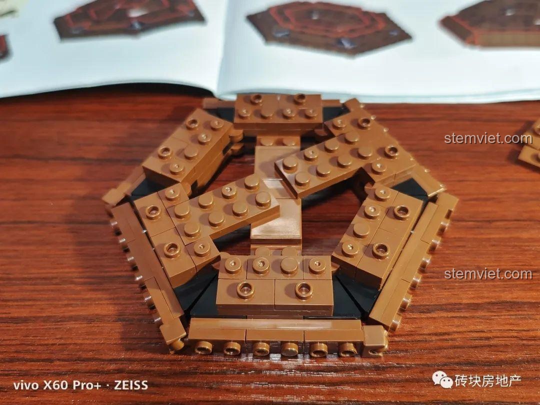 Phần đế của máy hát đĩa than cổ điển đang dần hoàn thiện với các chi tiết màu nâu và đen.