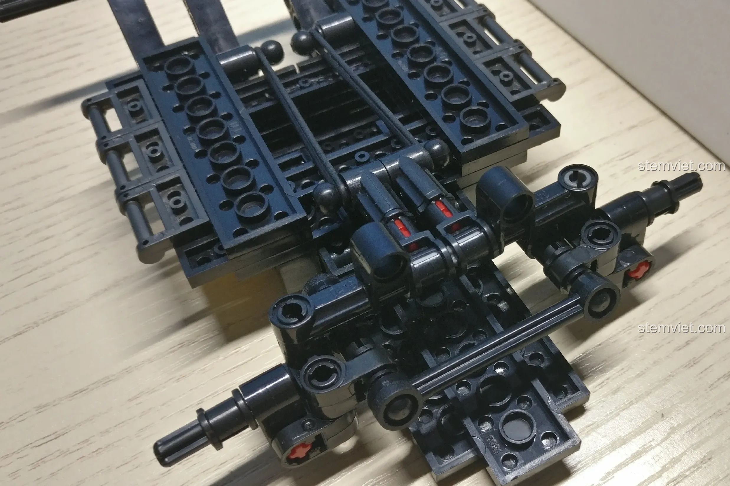 Giai đoạn đầu lắp ráp bộ đồ chơi Xe Jeep địa hình cho bé trai 6+, hoàn thiện phần khung gầm và hệ thống treo phức tạp.