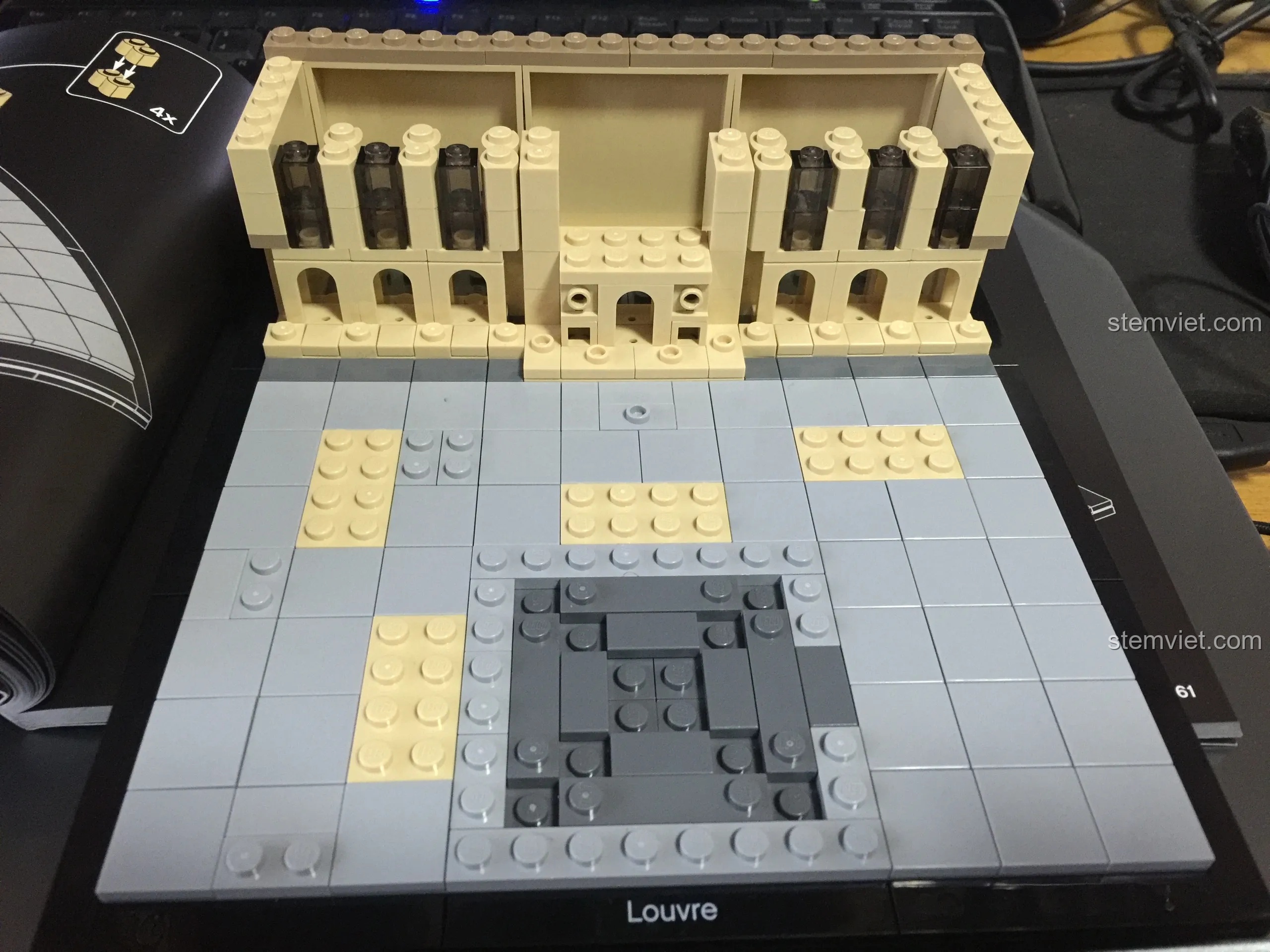 Lắp ráp tầng hai của cung điện Louvre trong bộ LEGO 21024, sử dụng các mảnh ghép trong suốt để làm cửa sổ.
