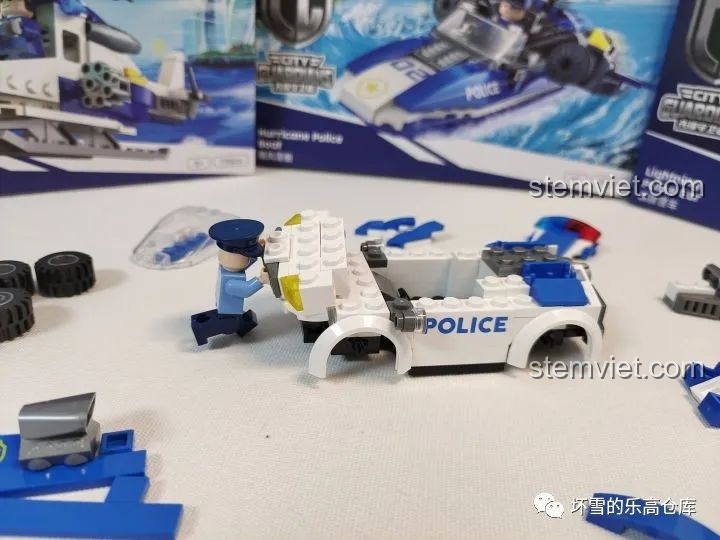 Nhân vật cảnh sát đang lắp ráp xe cảnh sát 'Tia Chớp' của JAKI City Guardians, với các mảnh ghép màu xanh trắng.