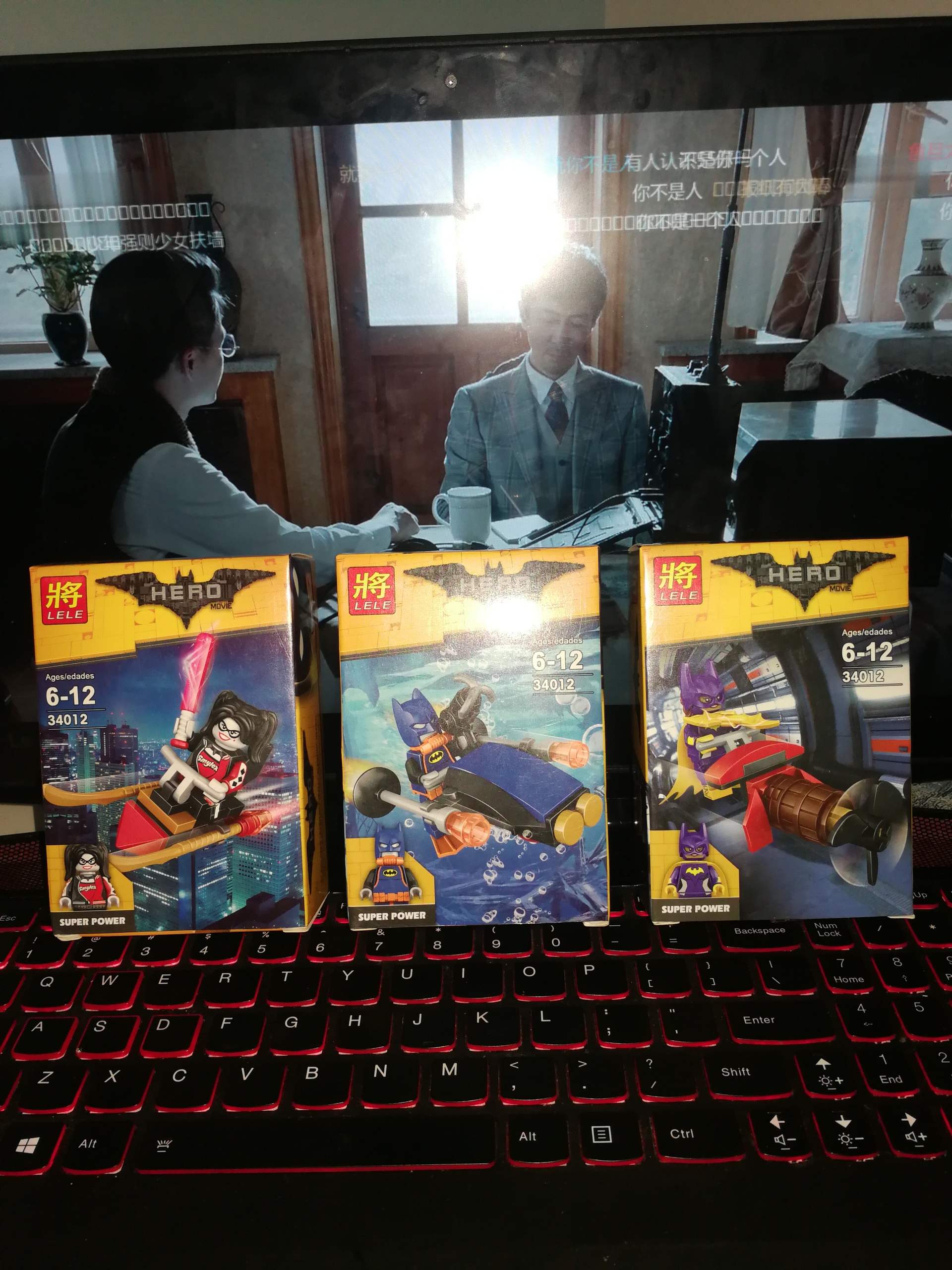 Ảnh chụp 3 hộp nhỏ của bộ lắp ráp Minifigure Batman LELE 34012, món đồ chơi hấp dẫn cho bé trai 6 tuổi.