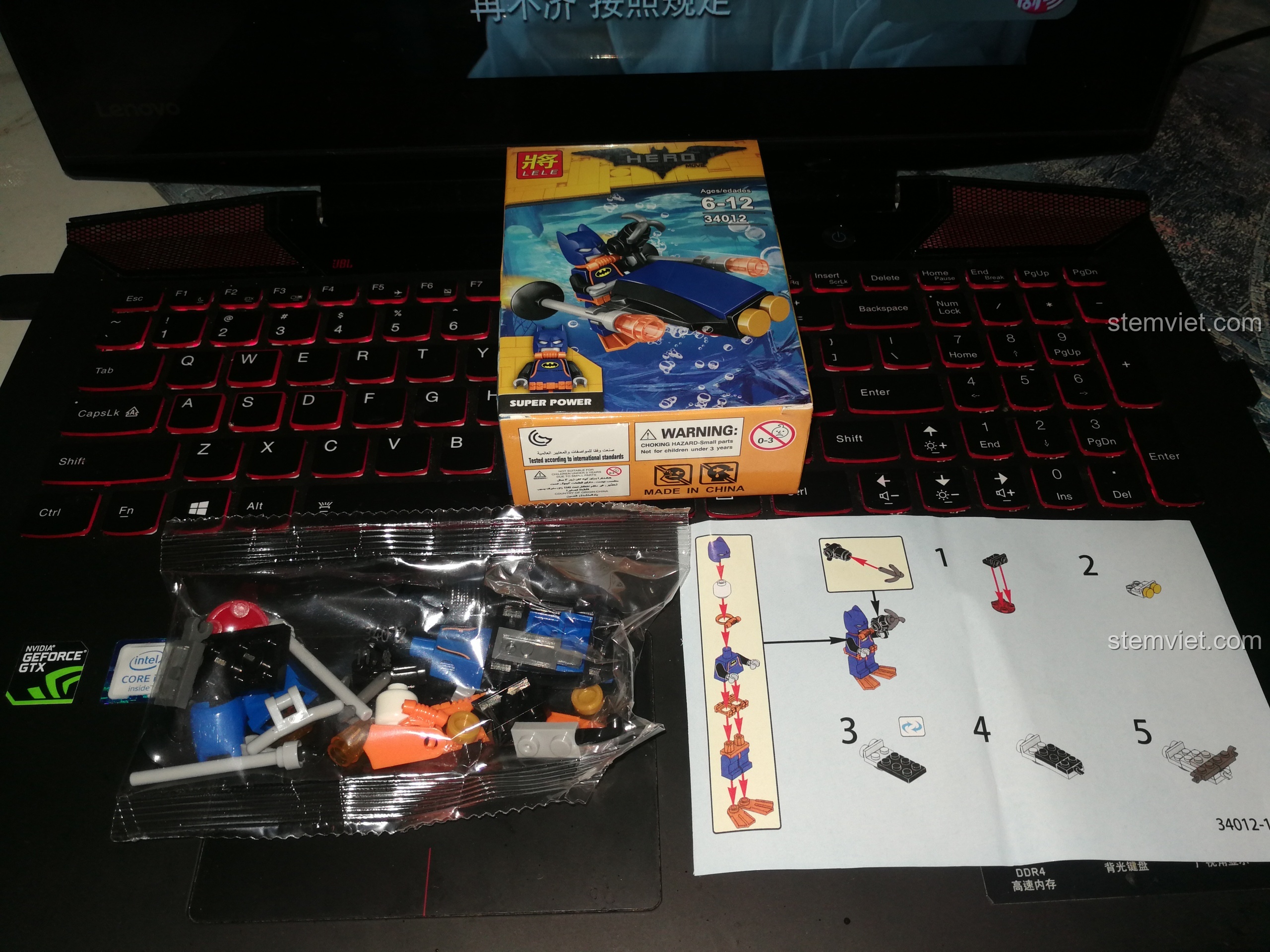 Mở hộp một set đồ chơi 34012, bên trong có túi chi tiết và giấy hướng dẫn lắp ráp nhân vật Batgirl.