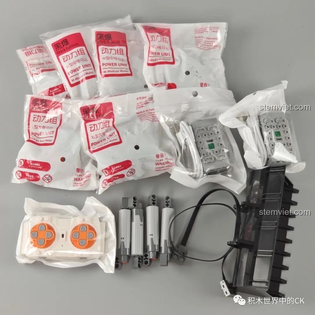 Toàn bộ các linh kiện điện tử của bộ Mould King 13112, gồm động cơ, hộp pin, tay cầm điều khiển và dây cáp.