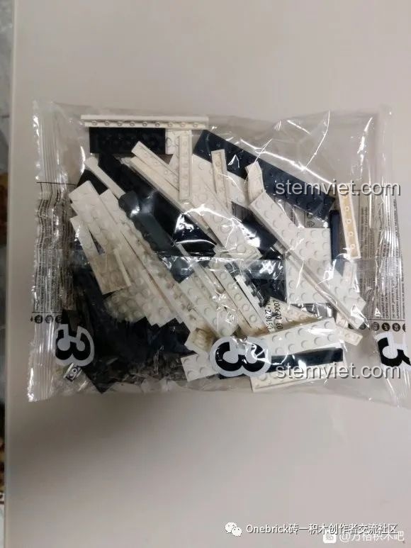 Túi linh kiện màu trắng của bộ lắp ráp CaDA C61022 Mazda RX-7 FC3S, sẵn sàng cho quá trình lắp ráp.