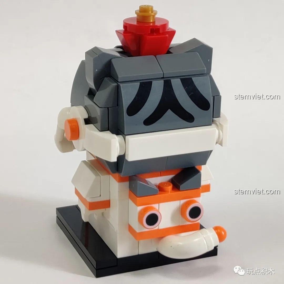 Các mảnh ghép in hình khuôn mặt, trang phục Môn Thần và chi tiết vàng óng của mô hình GUDI 52053.