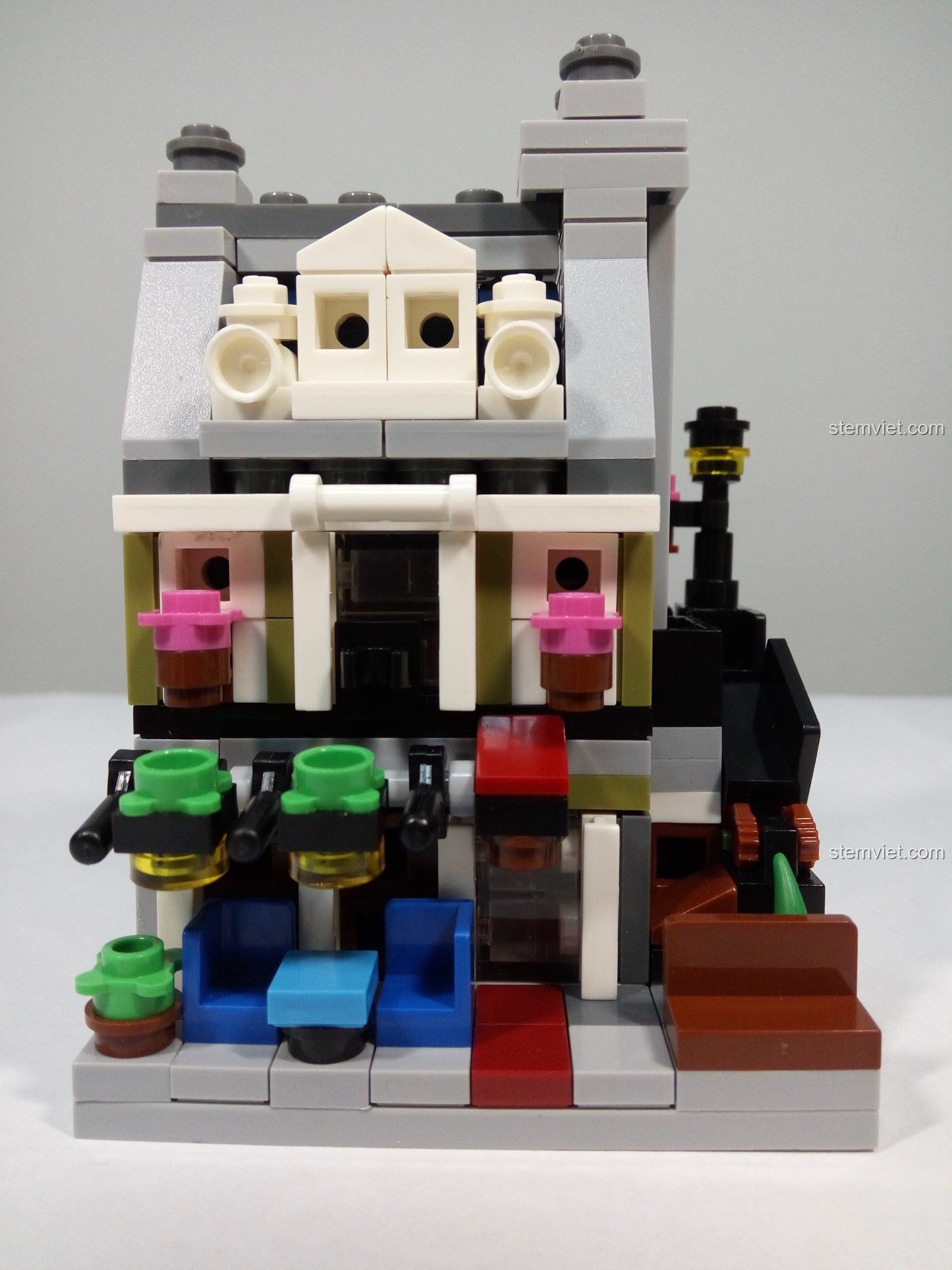 Mặt tiền của mô hình Nhà Hàng Paris Mini 1117 với bàn ghế và các chậu hoa nhỏ xinh.