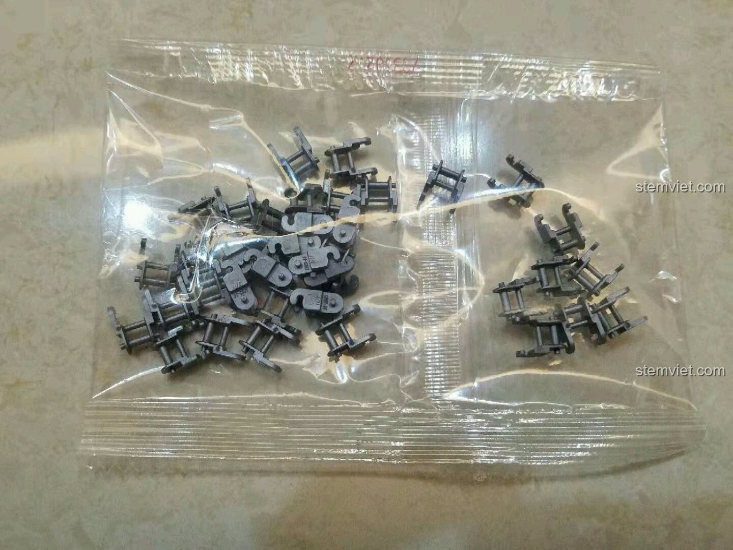 Túi nhựa chứa các mắt xích màu xám của bộ lắp ráp xe đạp địa hình Sembo 703302.