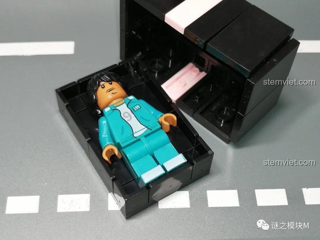 Minifigure Ali Abdul được đặt gọn gàng bên trong mô hình quan tài đã mở nắp.