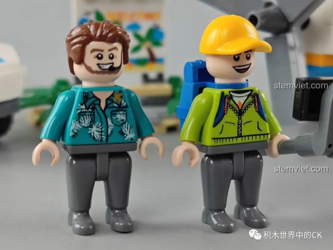 Cận cảnh hai nhân vật minifigure đi kèm bộ GUDI 10501 Máy bay tham quan Yakai, một người đeo tai nghe, người kia đội mũ và đeo ba lô.