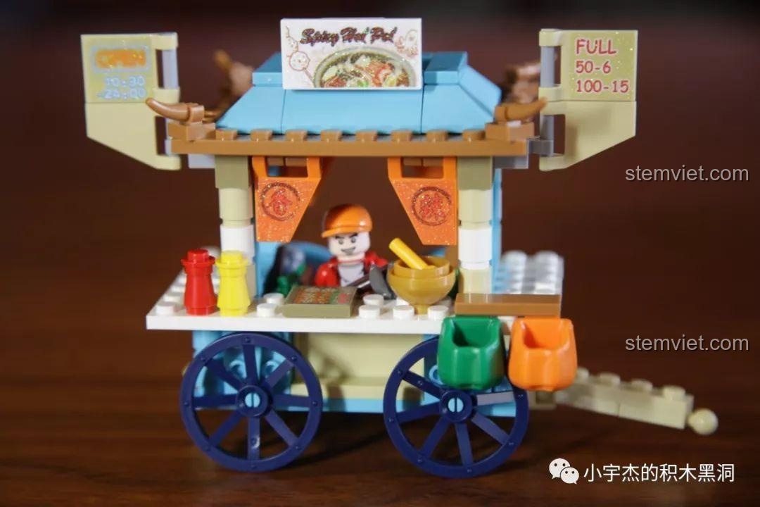 Mô hình xe lẩu cay Sembo 601115 với minifigure người bán đang chuẩn bị đồ ăn, tạo nên một khung cảnh sống động.