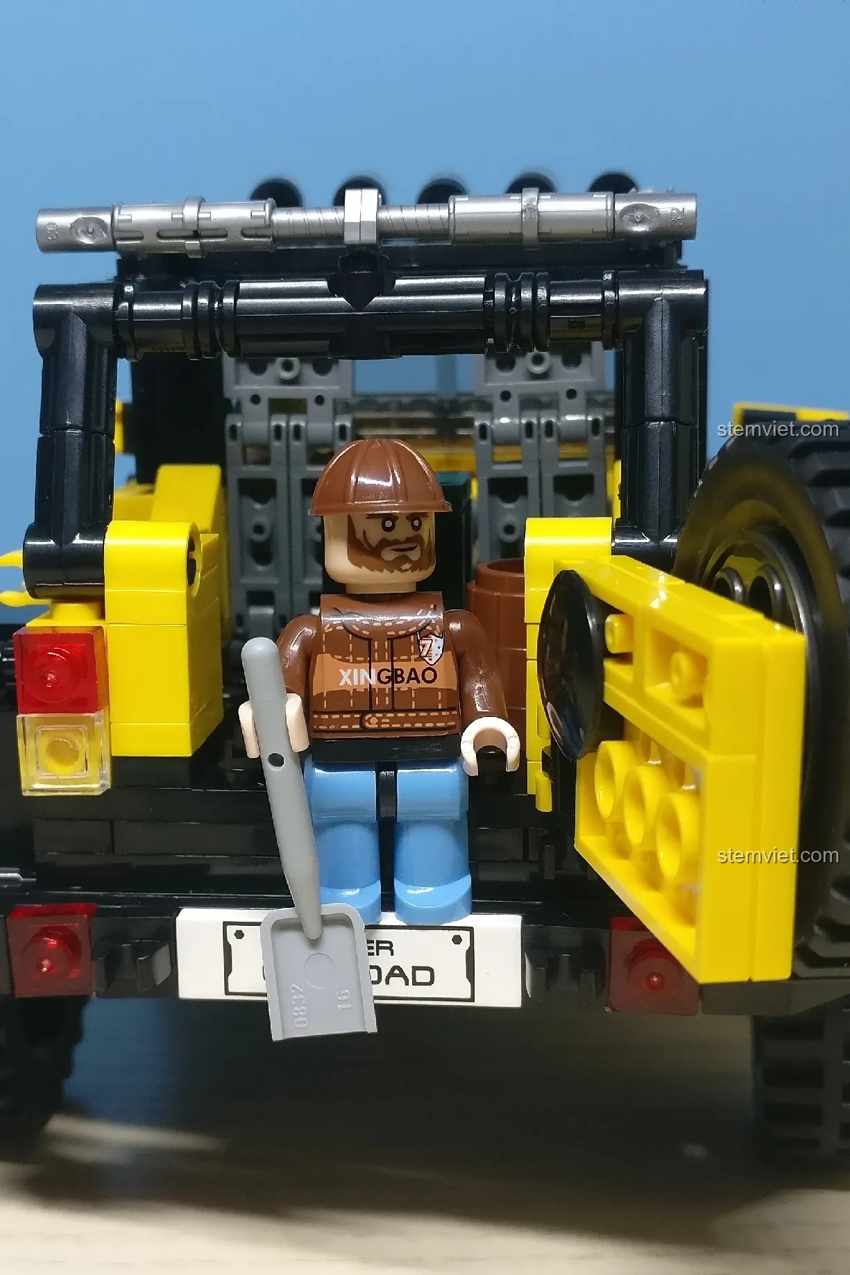 Minifigure thợ sửa xe đứng ở phía sau chiếc xe Jeep, tay cầm dụng cụ, sẵn sàng làm nhiệm vụ.