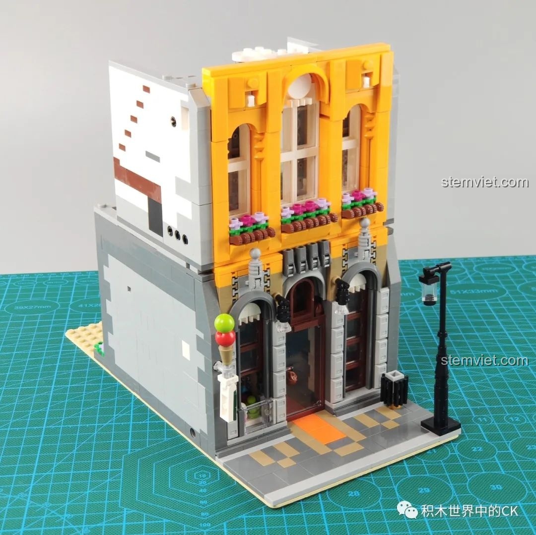 Mô hình Cửa Hàng Kem Leier 10003 đã lắp xong tầng một và tầng hai, mặt tiền màu vàng nổi bật đang dần hình thành.