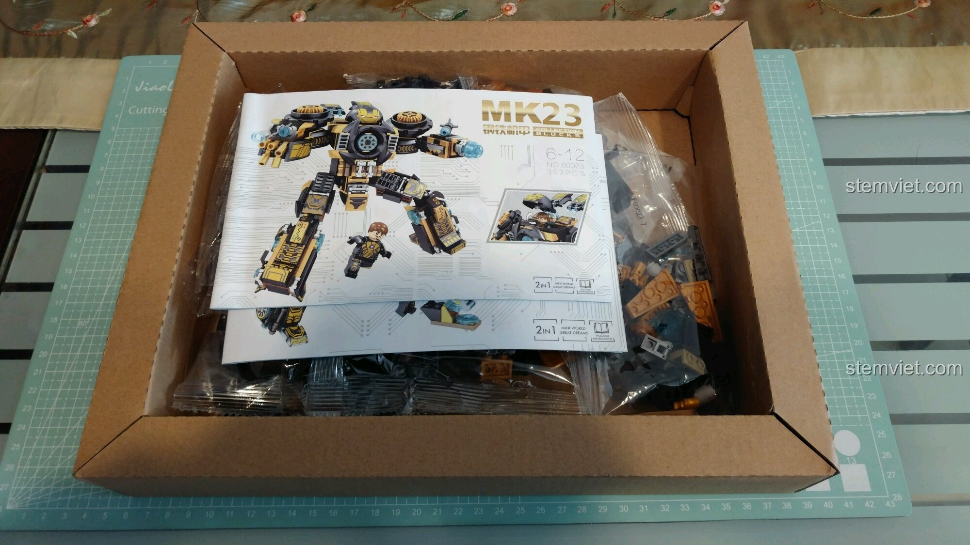 Bên trong hộp bộ đồ chơi Giáp Người Sắt MK23 cho trẻ 6 tuổi, gồm các túi mảnh ghép và sách hướng dẫn.