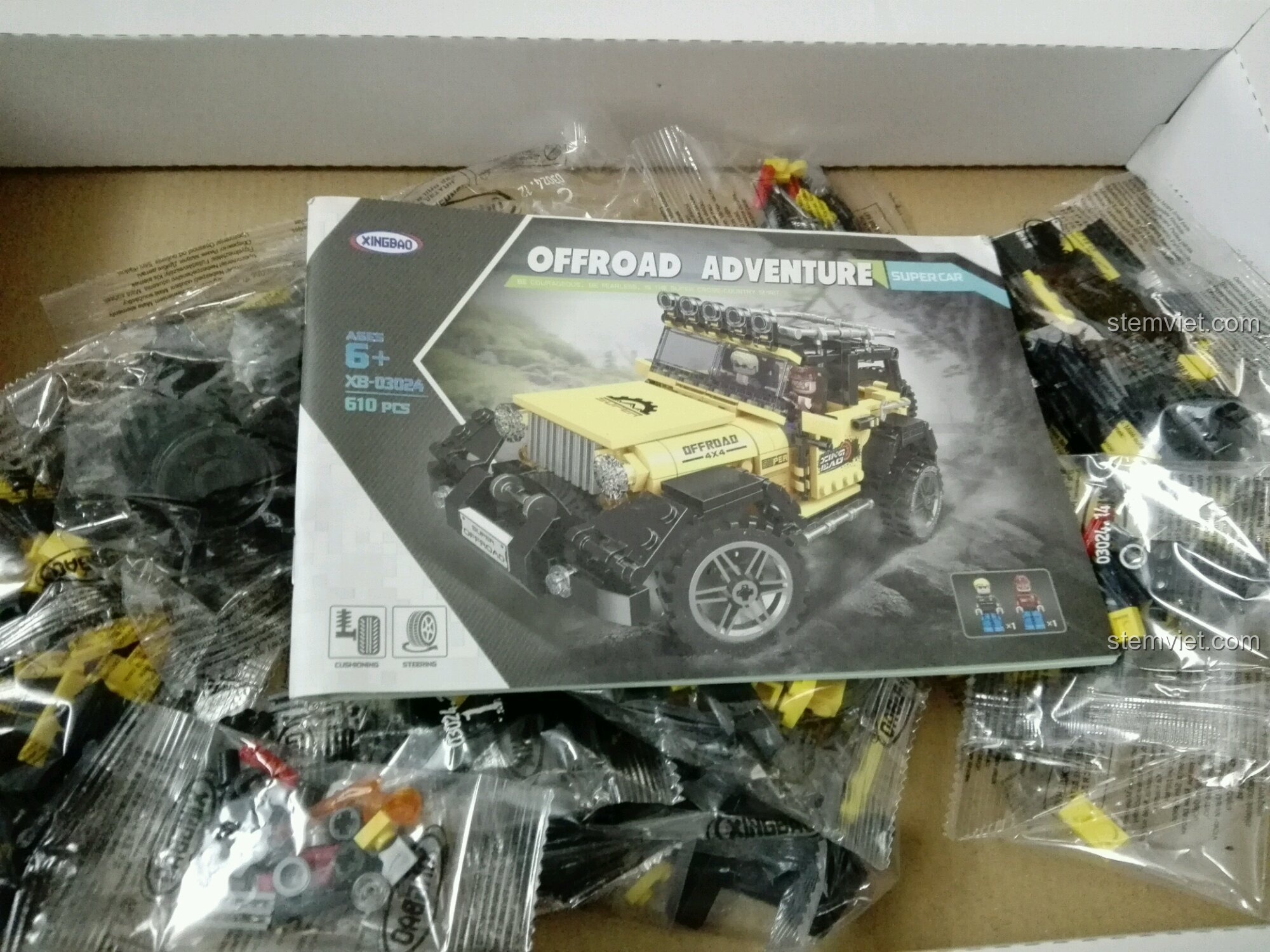 Bên trong hộp bộ đồ chơi Xe Jeep địa hình cho con trai từ 6 tuổi, gồm các túi chi tiết và sách hướng dẫn lắp ráp.