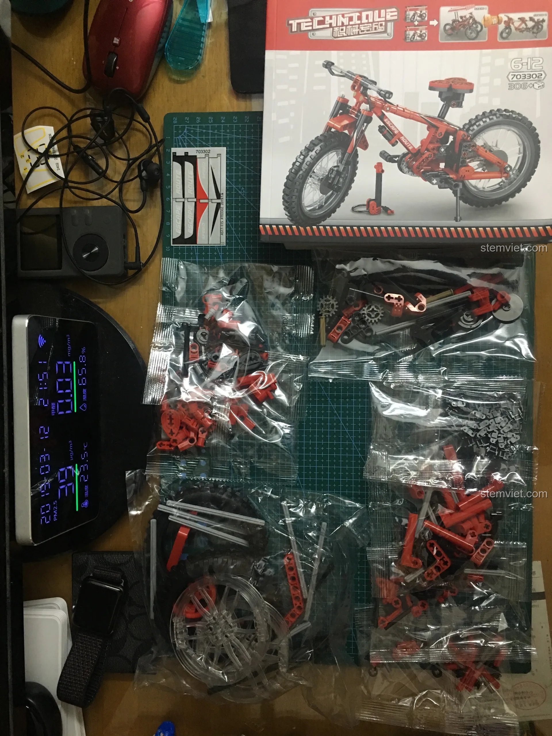 Toàn cảnh bên trong hộp đồ chơi lắp ghép Sembo 703302 với các túi nhựa chứa chi tiết và sách hướng dẫn lắp ráp.