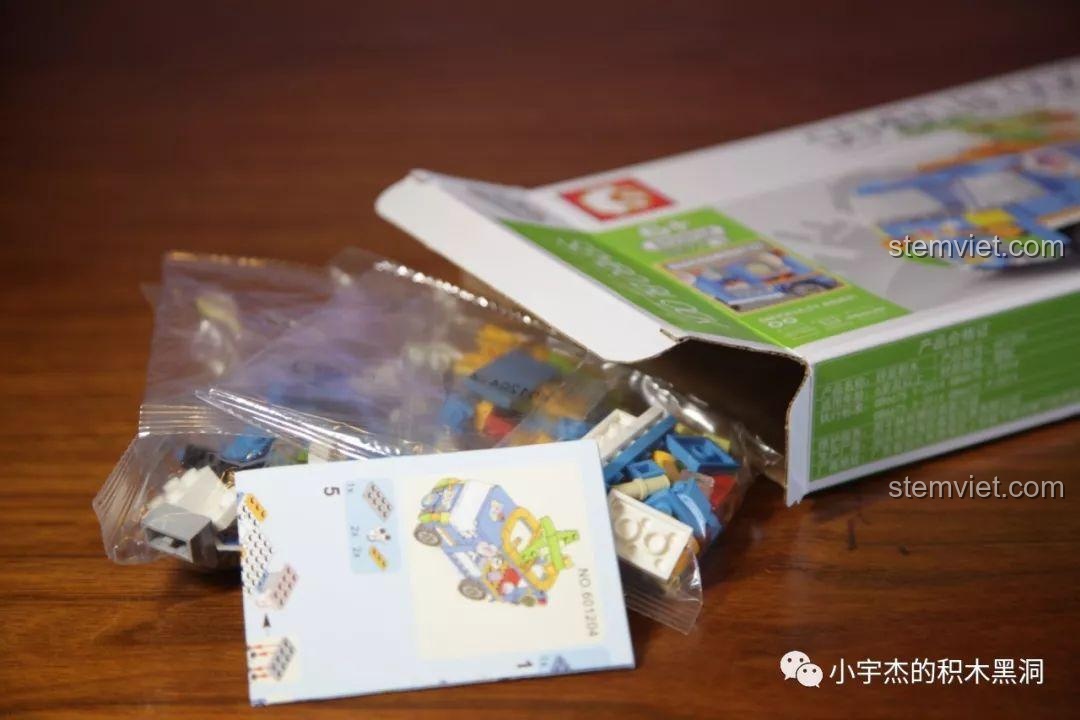 Mở hộp bộ lắp ráp Xe bán đồ chơi Sembo 601204, bên trong có túi chi tiết và sách hướng dẫn.