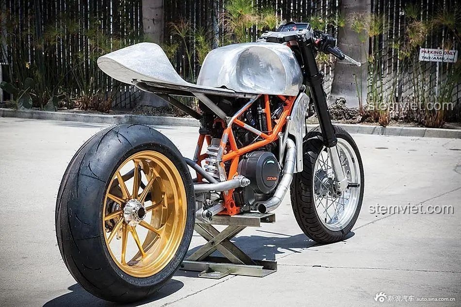 Hình ảnh một chiếc mô tô độ theo phong cách Cafe Racer với bình xăng bạc và bánh sau vàng đồng, thể hiện tinh thần của bộ lắp ráp Lucky Star 50025.