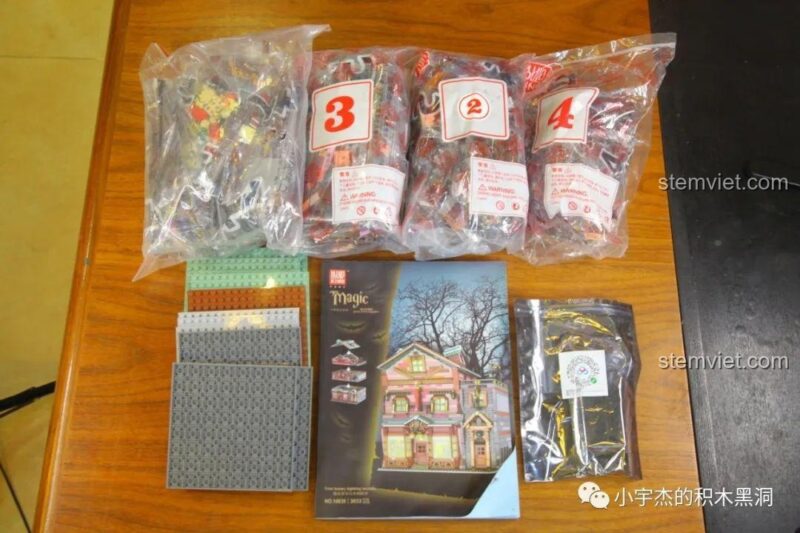 Toàn bộ các thành phần của bộ lắp ráp Cửa hàng phép thuật 16039, bao gồm sách hướng dẫn, các túi mảnh ghép và bộ đèn.