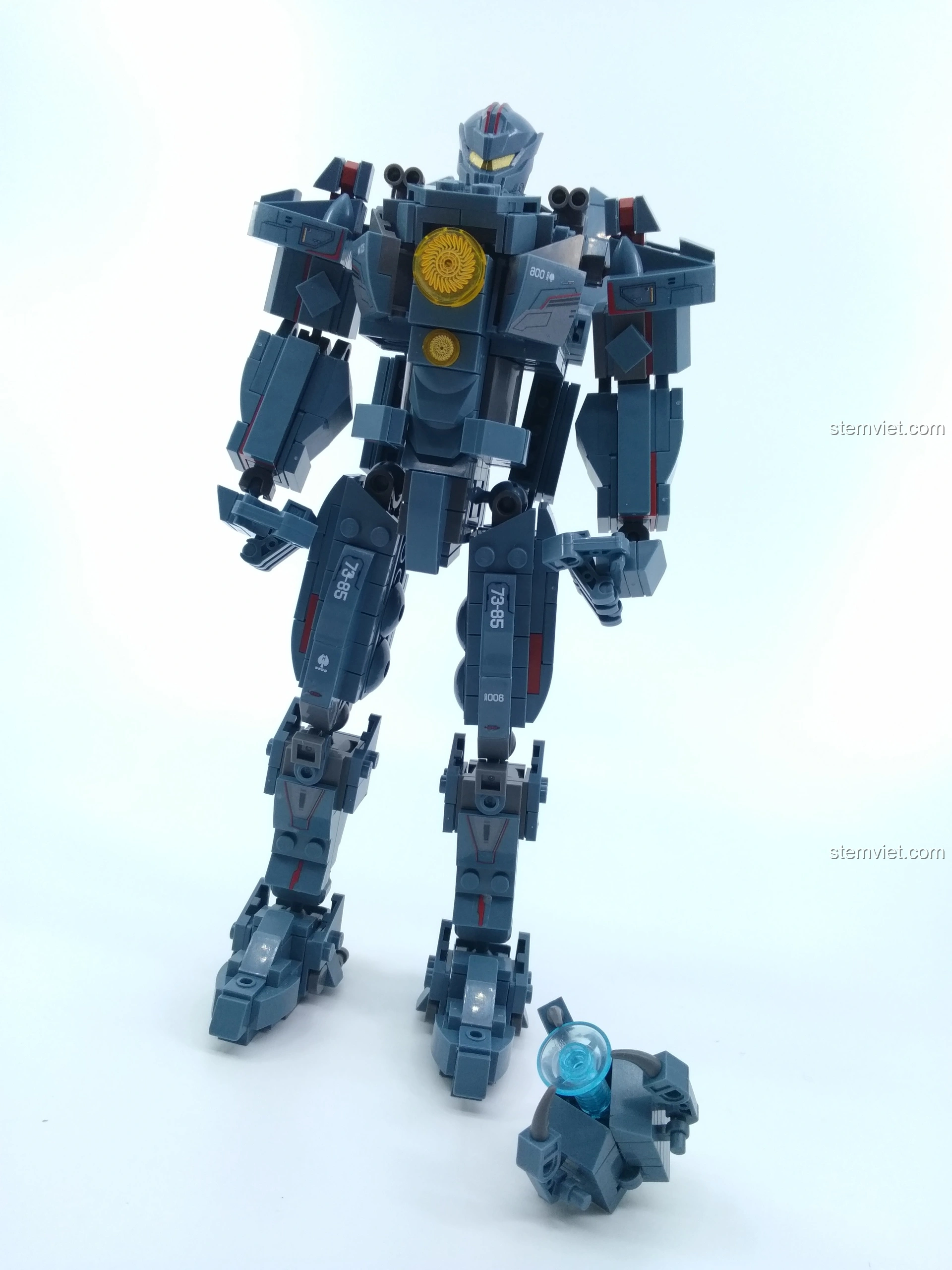 Người Máy Gipsy Avenger Sluban M38-B0726A đứng cạnh phụ kiện súng điện từ của mình.