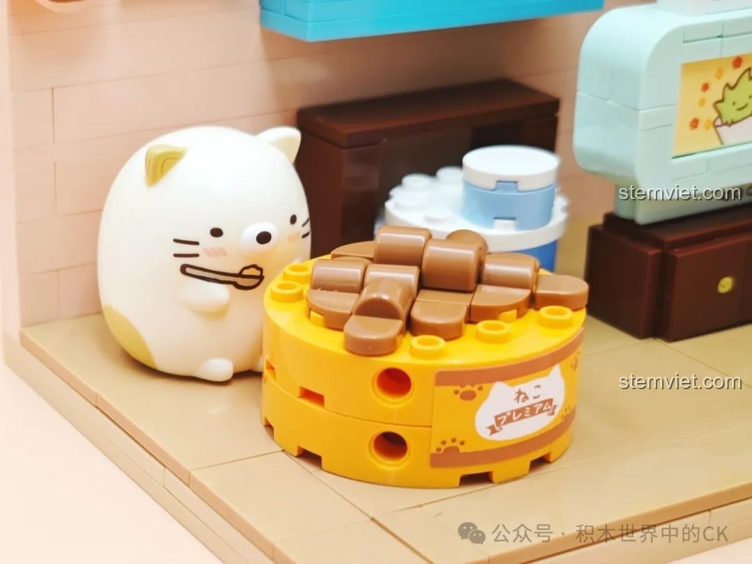 Cận cảnh nhân vật Neko đang ngồi bên chiếc ổ tròn trong bộ đồ chơi lắp ráp Keeppley Sumikko Gurashi K21210.