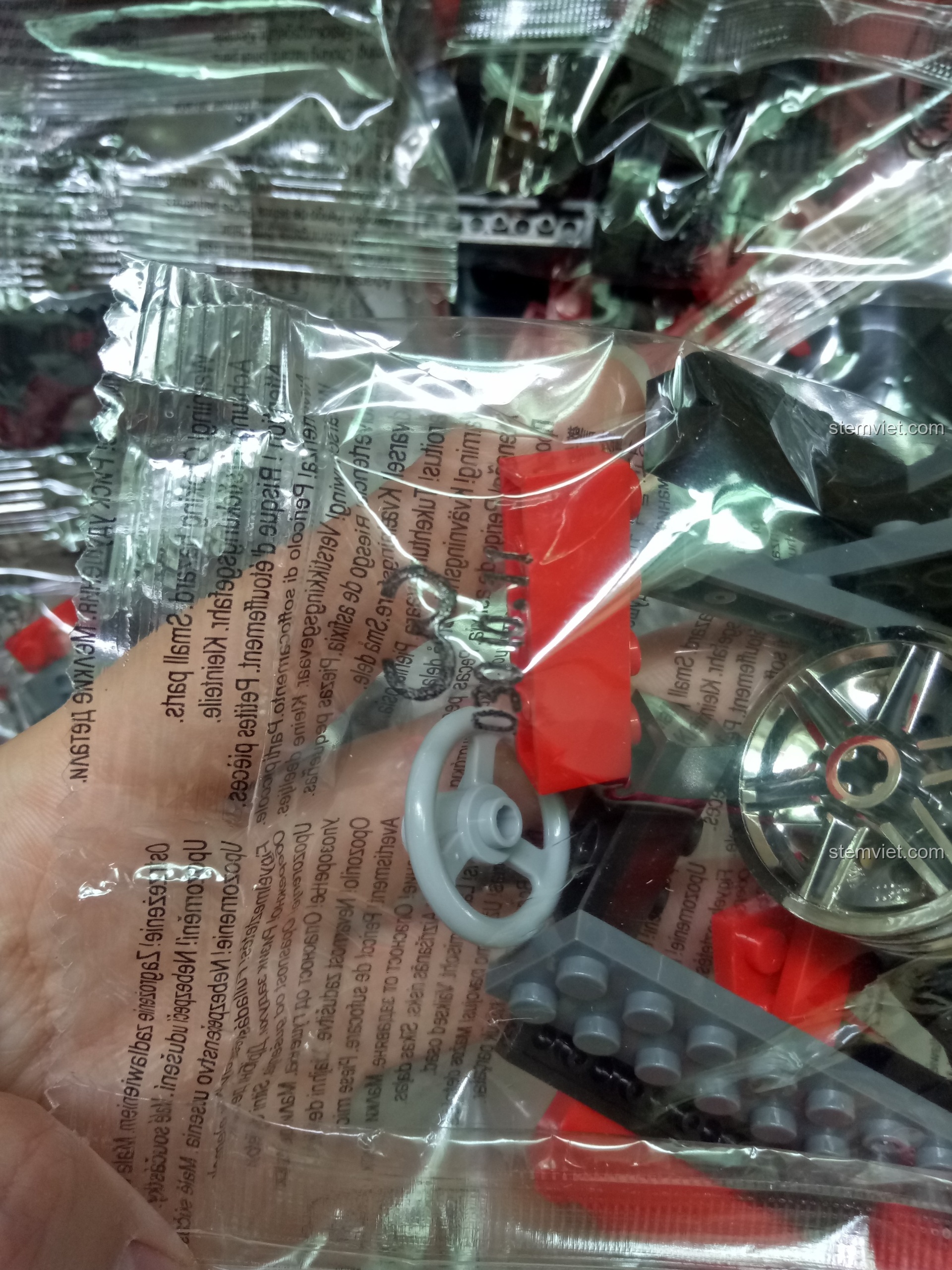 Cận cảnh một túi gạch trong bộ đồ chơi mô hình Biểu tượng xe hơi Đức Mercedes 300SL 3010, có thể thấy chi tiết vô lăng.