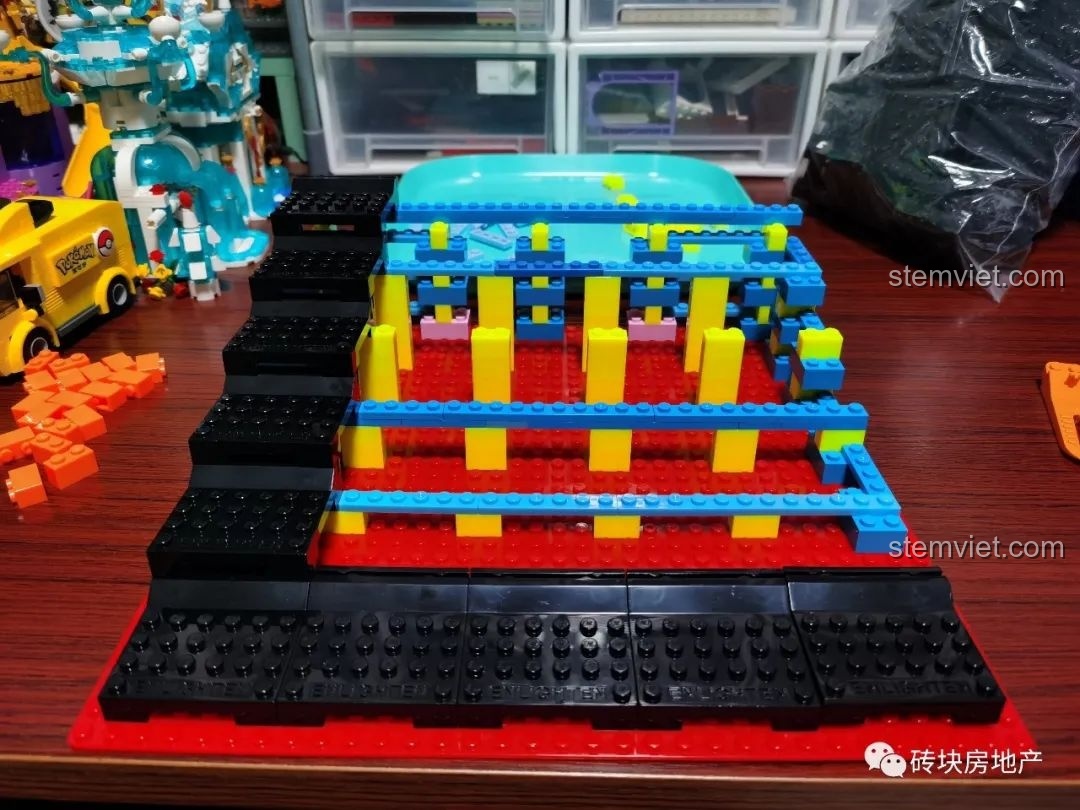 Các đế gắn minifigure màu đen được đặt lên các bậc thang, chuẩn bị cho việc trưng bày nhân vật.