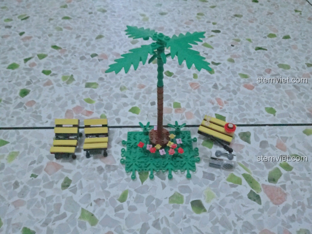 Toàn bộ phụ kiện ngoại cảnh của bộ Xingbao XB-08003 gồm cây dừa, ghế, bàn và radio.