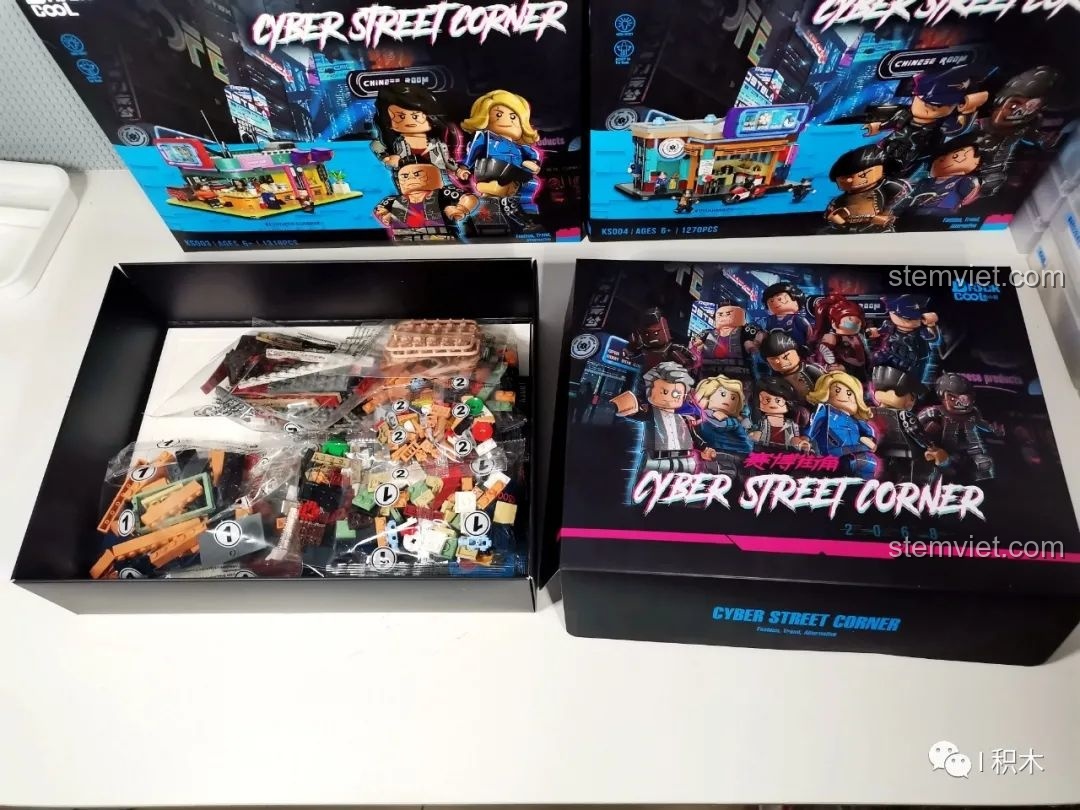 Bên trong hộp đồ chơi lắp ráp BrickCool KS001 Quán Cà Phê Cyberpunk, lộ ra các túi chi tiết và tấm bìa cứng bảo vệ.