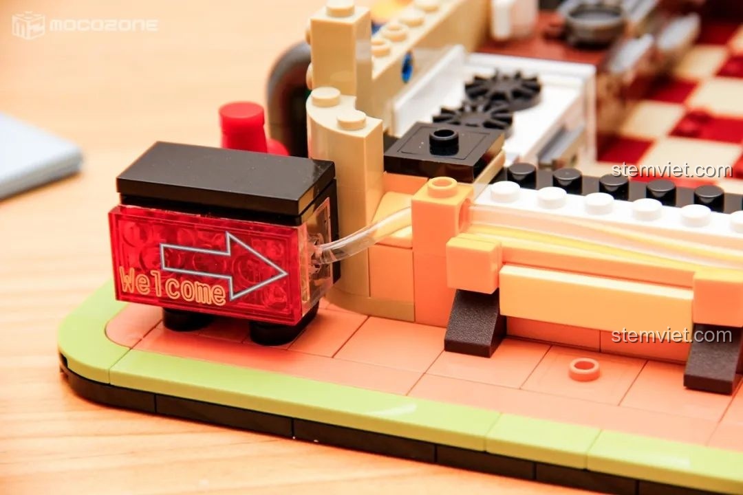 Cơ chế dẫn sáng tích hợp vào mô hình BrickCool KS001 Quán Cà Phê Cyberpunk, cho thấy cách ánh sáng truyền từ nguồn đến biển hiệu 'Welcome'.