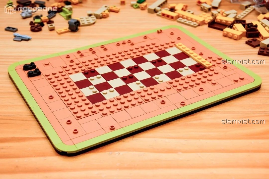 Phần đế của mô hình quán cà phê trong bộ BrickCool KS001 đang được xây dựng, với các ô vuông màu đỏ và trắng tạo điểm nhấn.