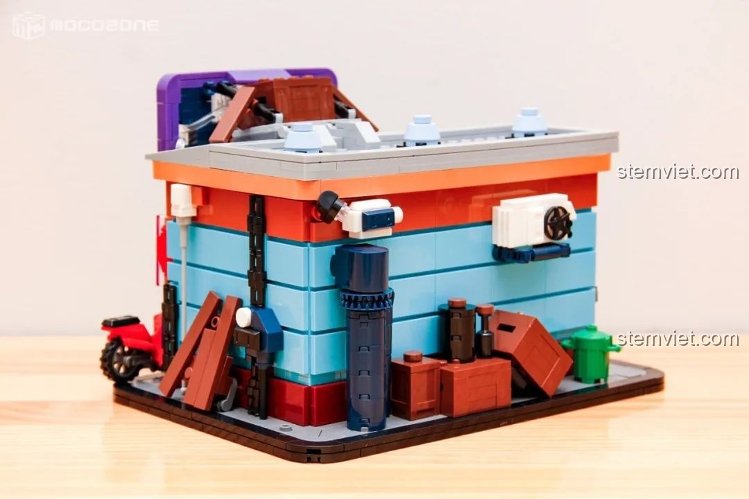 Mặt sau của một mô hình đồ chơi lắp ráp BrickCool KS001, với các đường ống, thùng rác và hộp gỗ, tạo nên khung cảnh đô thị chân thực.