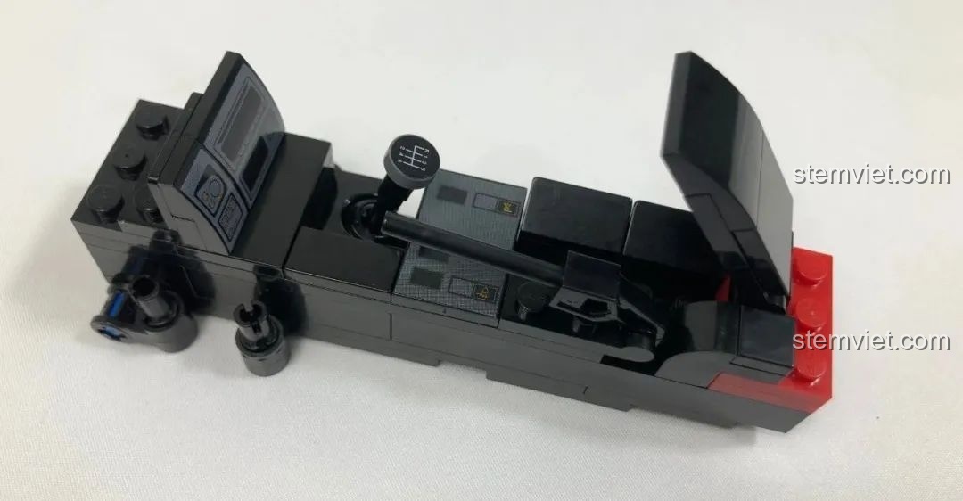 Cần gạt màu vàng để điều khiển đèn pop-up được giấu phía sau bảng điều khiển của mô hình CaDA C61022 Mazda RX-7 FC3S.