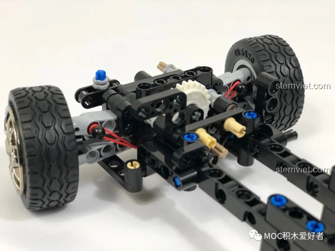 Khung gầm phía trước của mô hình CaDA C61022 Mazda RX-7 FC3S đang được lắp ráp, hiển thị hệ thống lái và giảm xóc.