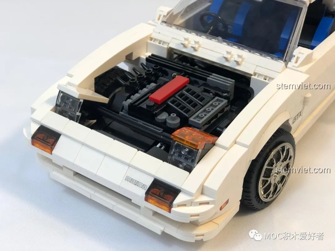 Góc nhìn 3/4 từ phía sau của mô hình CaDA C61022 Mazda RX-7 FC3S phiên bản Project D, với cánh gió lớn nổi bật.