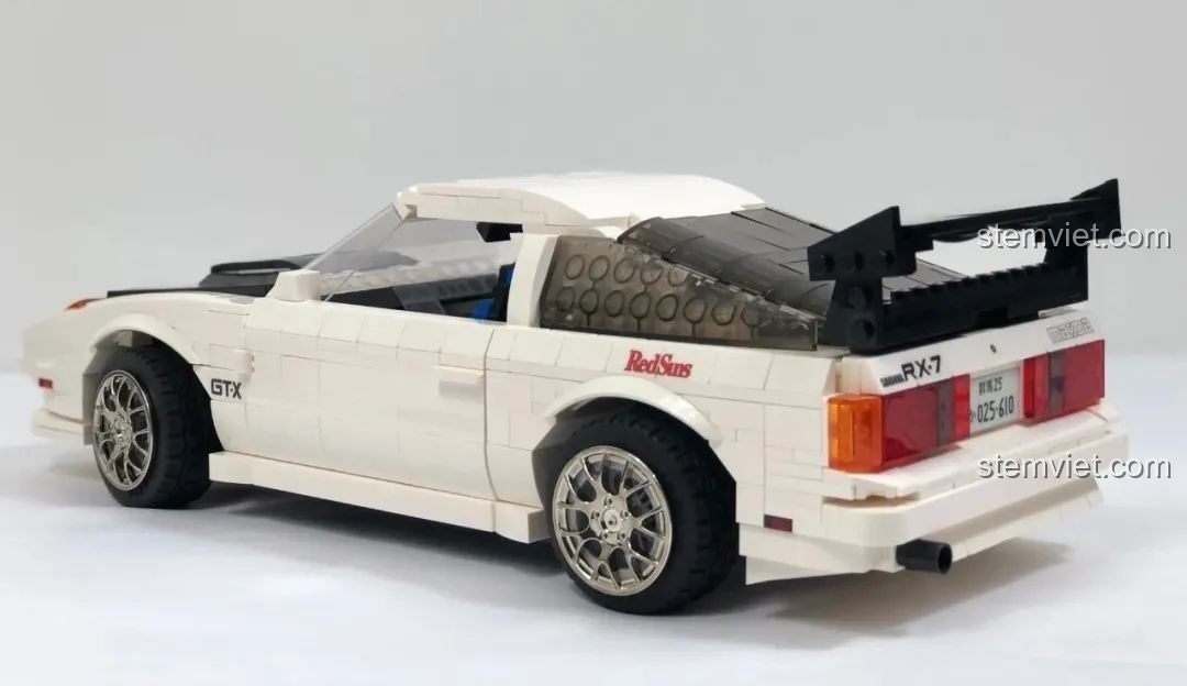 Góc nhìn 3/4 từ phía sau của mô hình CaDA C61022 Mazda RX-7 FC3S trên giá trưng bày, trông ấn tượng và sẵn sàng bứt tốc.