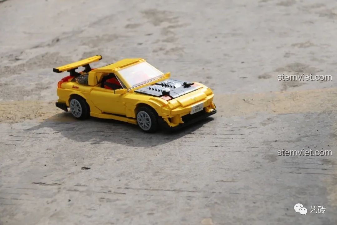 Cận cảnh mô hình CaDA C61023 Mazda RX-7 FD3S phiên bản Project D từ bên hông, cho thấy tỉ lệ chuẩn và thiết kế khí động học của xe.