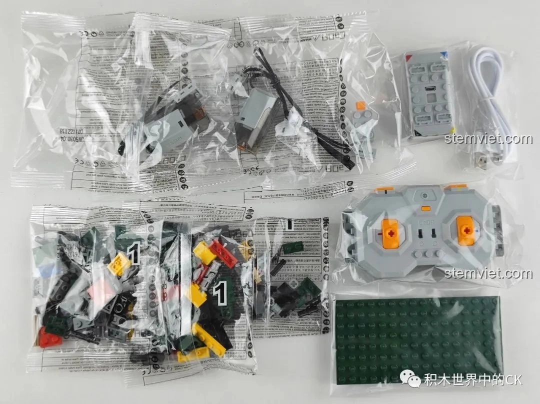 Toàn bộ linh kiện bên trong hộp đồ chơi CaDA C61072 Xe tăng hạng trung T-34, bao gồm các túi mảnh ghép, động cơ, điều khiển từ xa và dây sạc.