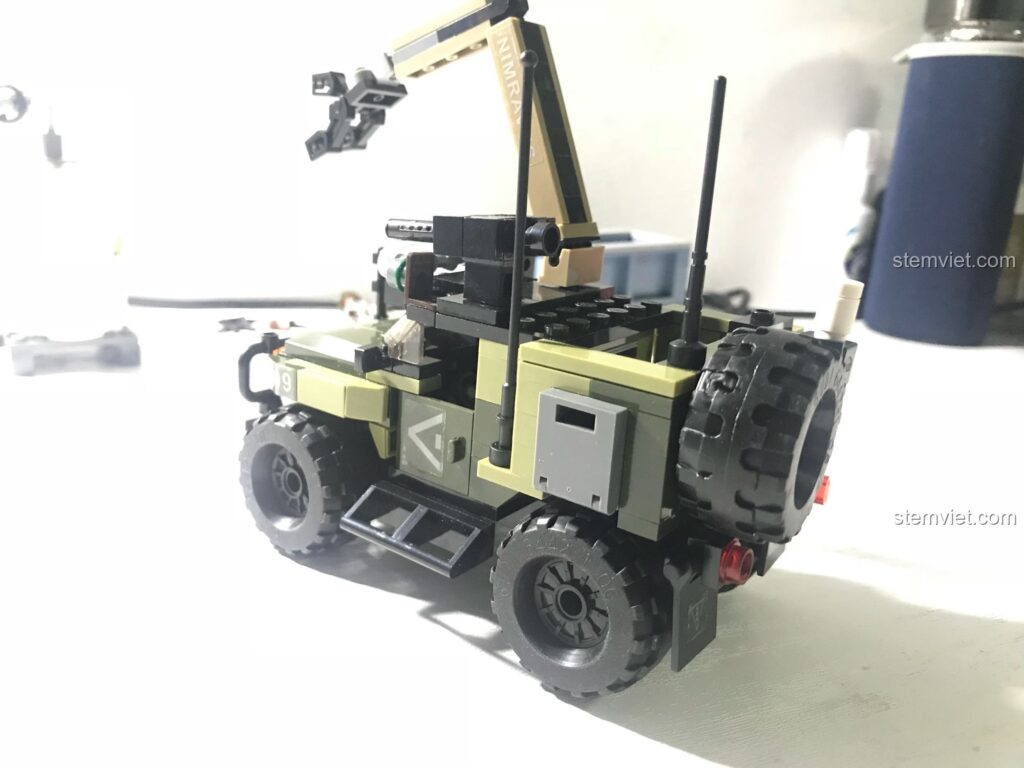 Góc nhìn từ phía sau của xe jeep quân sự trong bộ lắp ráp GUDI 8034, cho thấy bánh xe dự phòng và các chi tiết nhỏ.