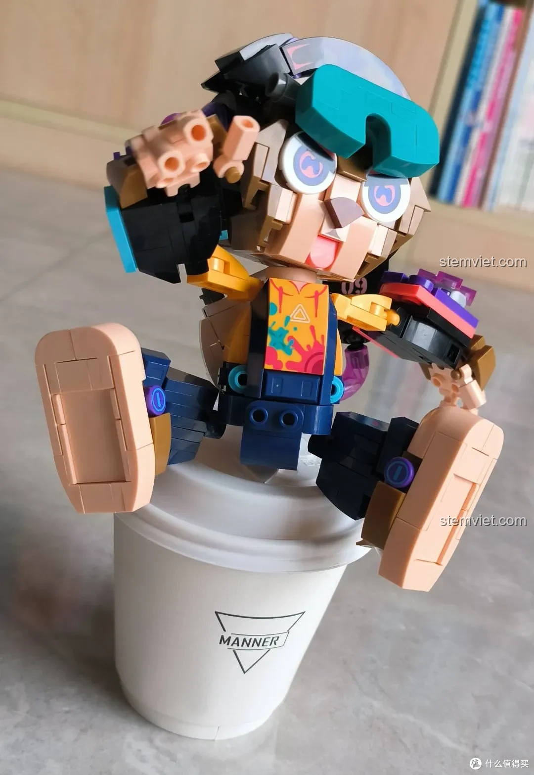 Mô hình iBlock Tuyển Thủ E-sport Thân Hầu ib1001-9 đang ngồi trên cốc, thể hiện khả năng tạo dáng linh hoạt và vui nhộn.