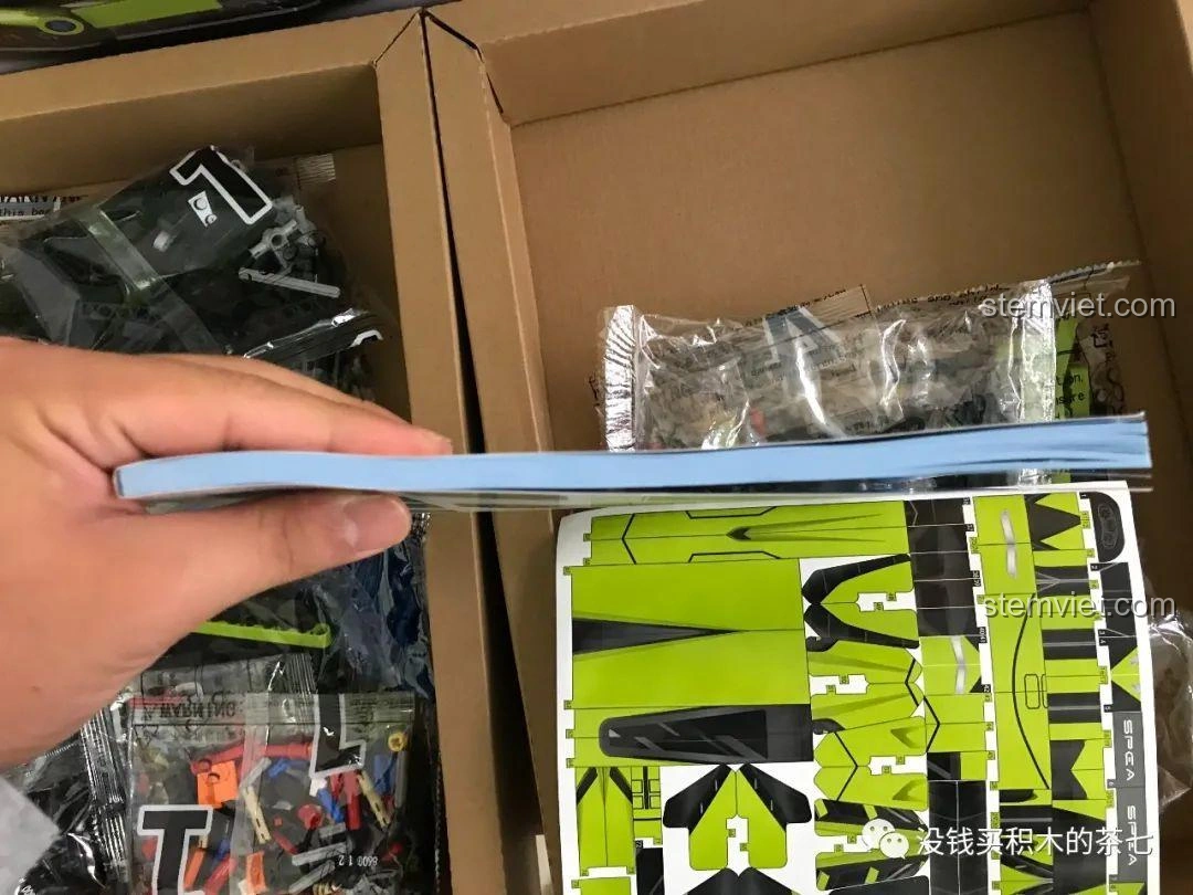 Độ dày của sách hướng dẫn lắp ráp Jiazhi Blocks 8600 Lamborghini Sián FKP 37, cho thấy sự phức tạp của mô hình.