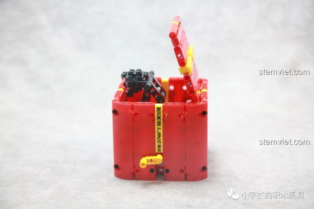 Cơ chế弹射 (ejection) của bộ lắp ráp Hộp Quà Giáng Sinh QJ5243 hoạt động trơn tru sau khi thay thế mảnh lỗi, sẵn sàng bật mở hộp.