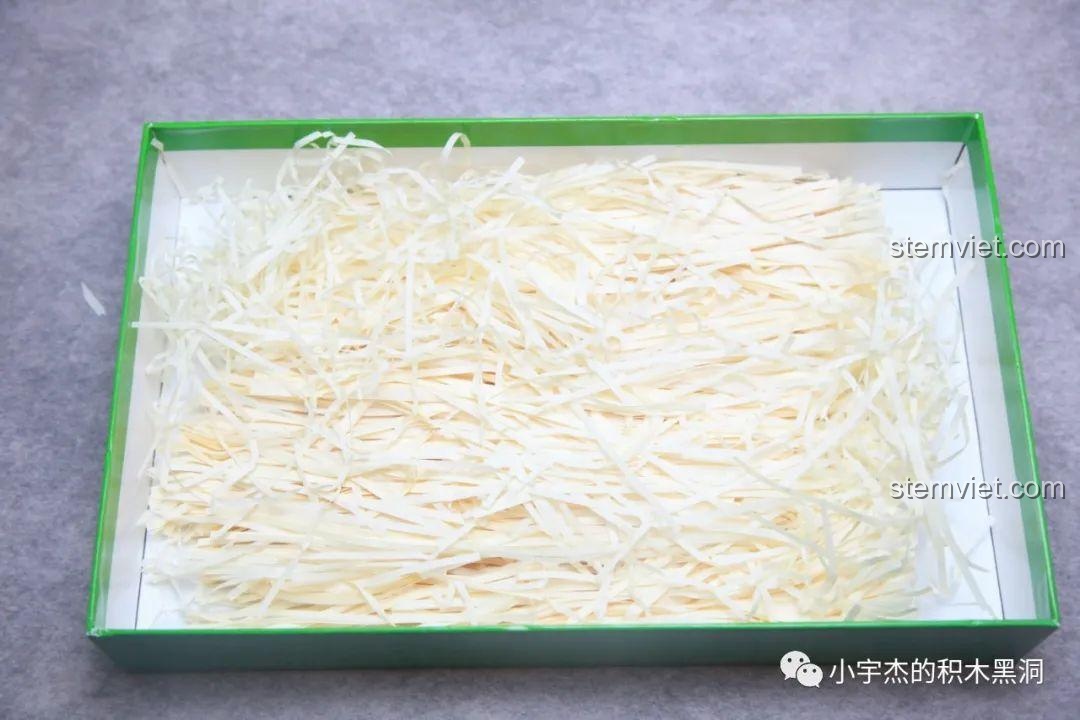 Lớp giấy vụn lót đáy hộp bộ đồ chơi xếp hình Hộp quà lễ hội Giáng Sinh 243, tạo cảm giác như một hộp quà thật.