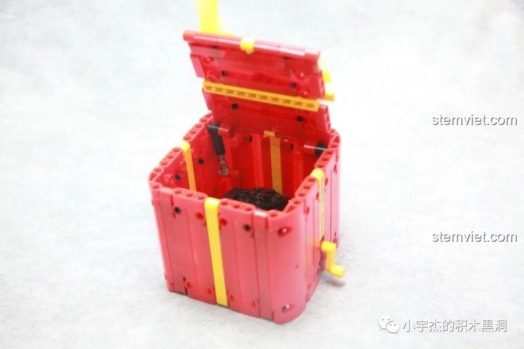 Tay quay điều khiển cơ chế mở hộp của bộ lắp ráp Hộp Quà Giáng Sinh QJ5243, tạo sự tương tác độc đáo.