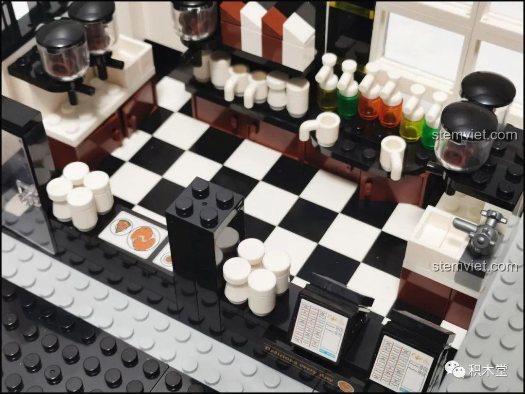 Cận cảnh khu vực pha chế của Juhang 86007 Quán Cà Phê Góc Phố, với các chi tiết như ly, tách, và máy tính màn hình kép, tạo sự chân thực.