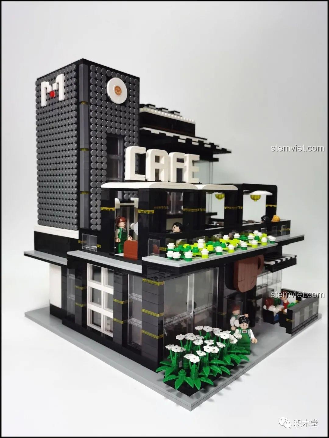 Nhìn xuyên qua cửa kính trong suốt của mô hình Juhang 86007 Quán Cà Phê Góc Phố, thấy rõ nội thất bên trong quán, tạo cảm giác chân thực.