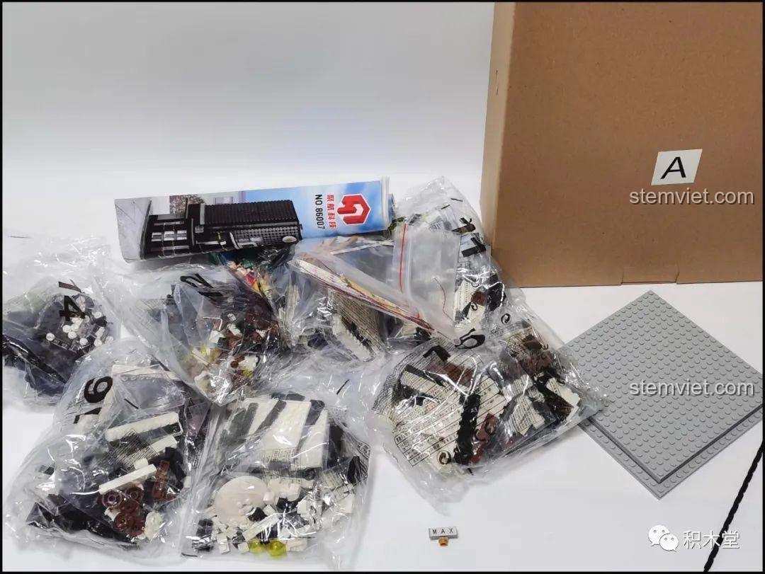 Nội dung hộp A của bộ Juhang 86007 Quán Cà Phê Góc Phố, bao gồm các túi mảnh ghép được đánh số, sách hướng dẫn và các tấm đế lắp ráp.