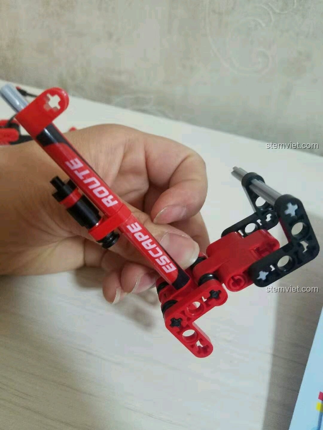 Bàn tay đang cầm phần khung sườn chính của xe đạp Sembo 703302 đã được dán sticker.