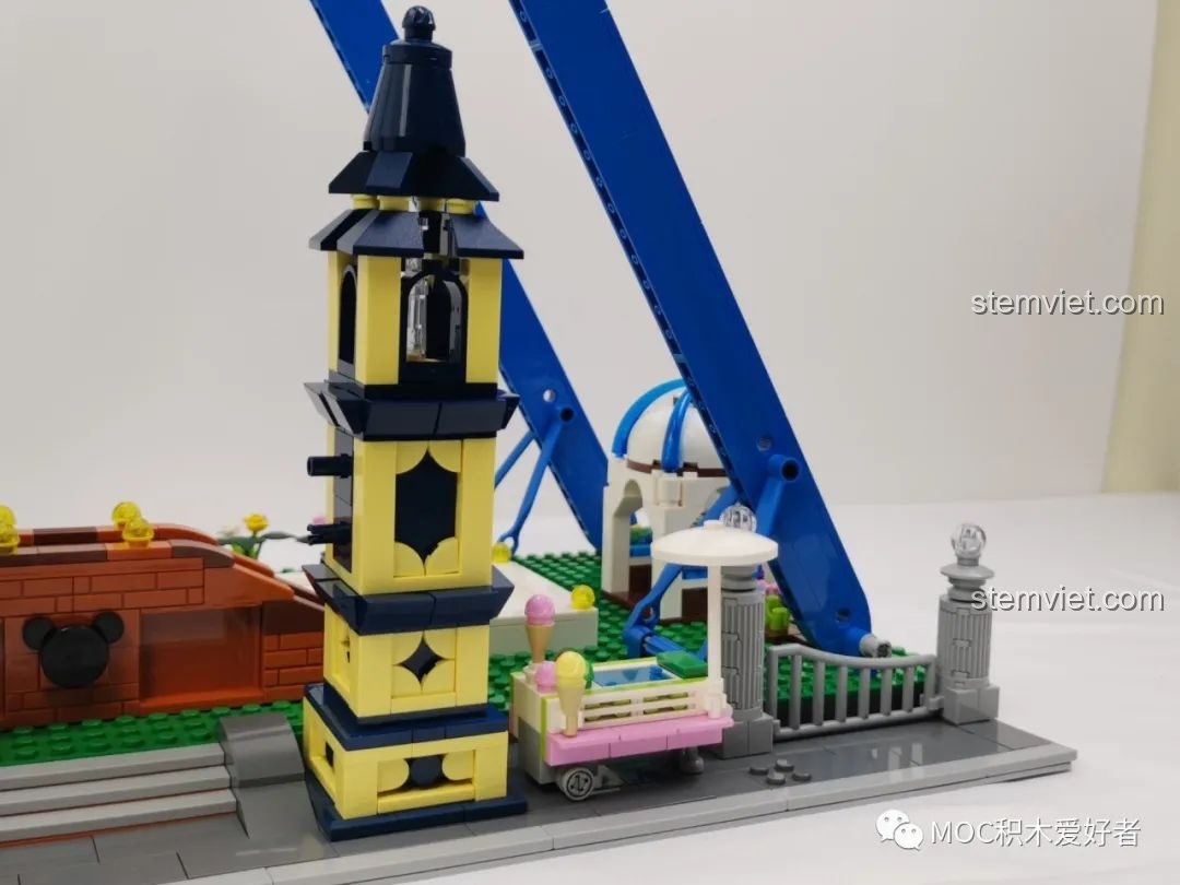 Khu vực cổng vào Vòng Quay Khổng Lồ Mould King 11006 với tháp đồng hồ, quầy bán vé tự động và xe kem.